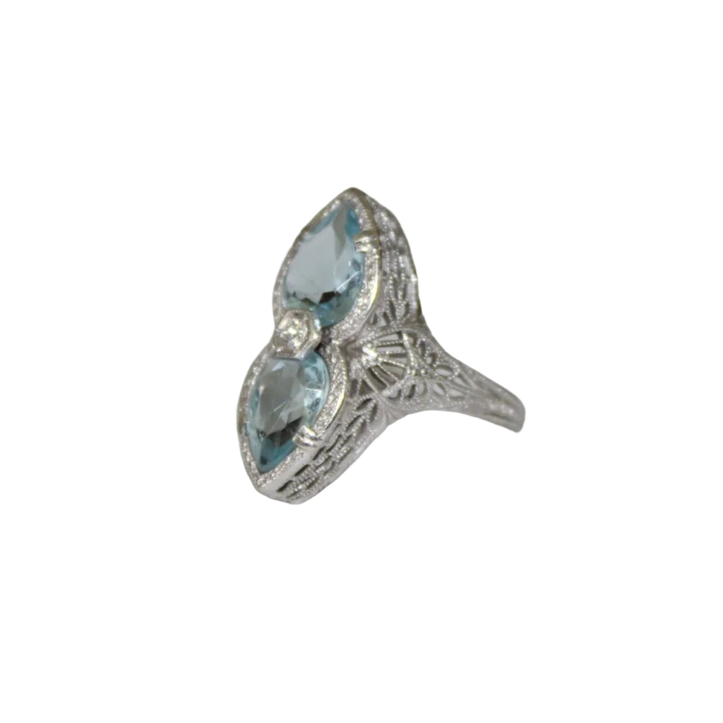 Silver ring with blue gemstones on a white surface