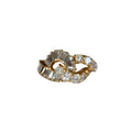 Gold ring with diamond accents on a light gray background