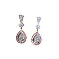 Teardrop-shaped earrings with gemstones on a beige fabric background