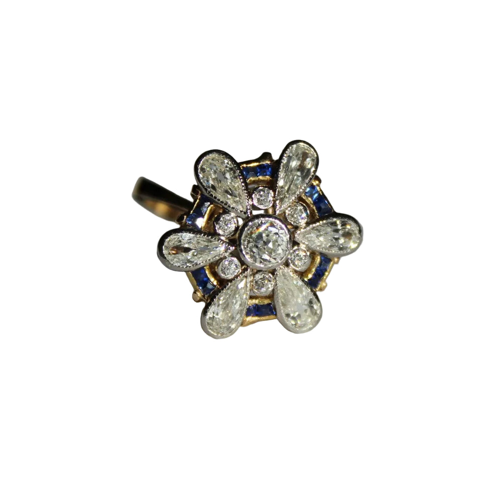 Gold ring with diamond and blue gemstone design on a white background