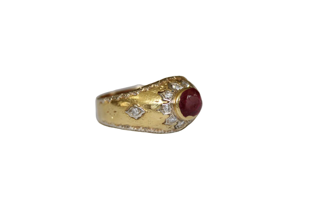 Gold ring with a ruby and diamonds on a white background