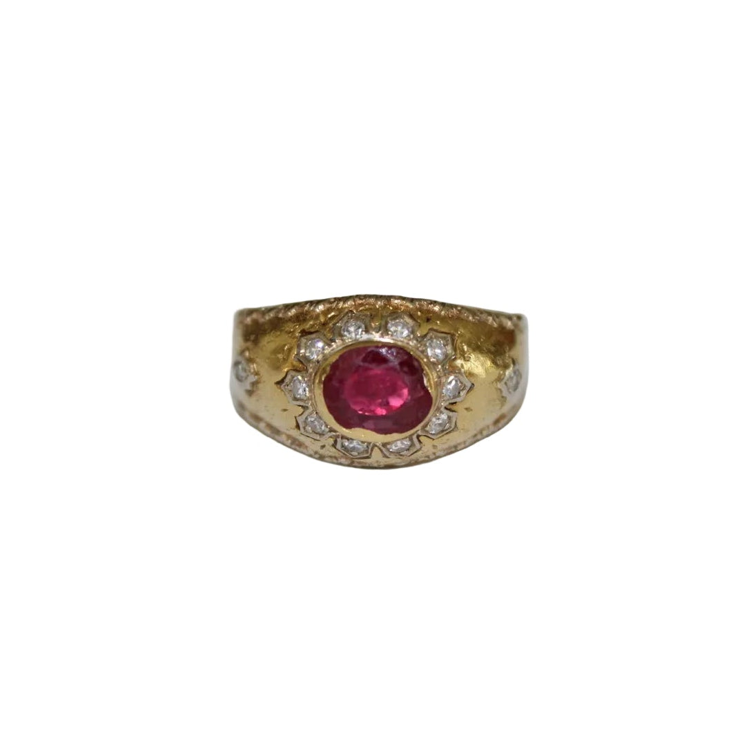 Gold ring with a ruby and diamonds on a white background