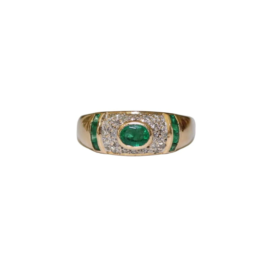 Gold ring with emerald and diamonds on a white background