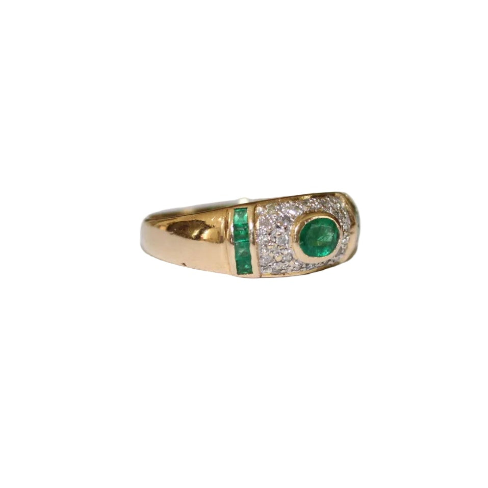 Gold ring with emerald and diamond accents on a white background