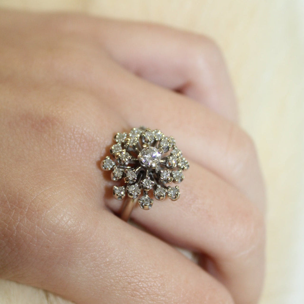 Close-up of a hand wearing a decorative ring with multiple diamonds.