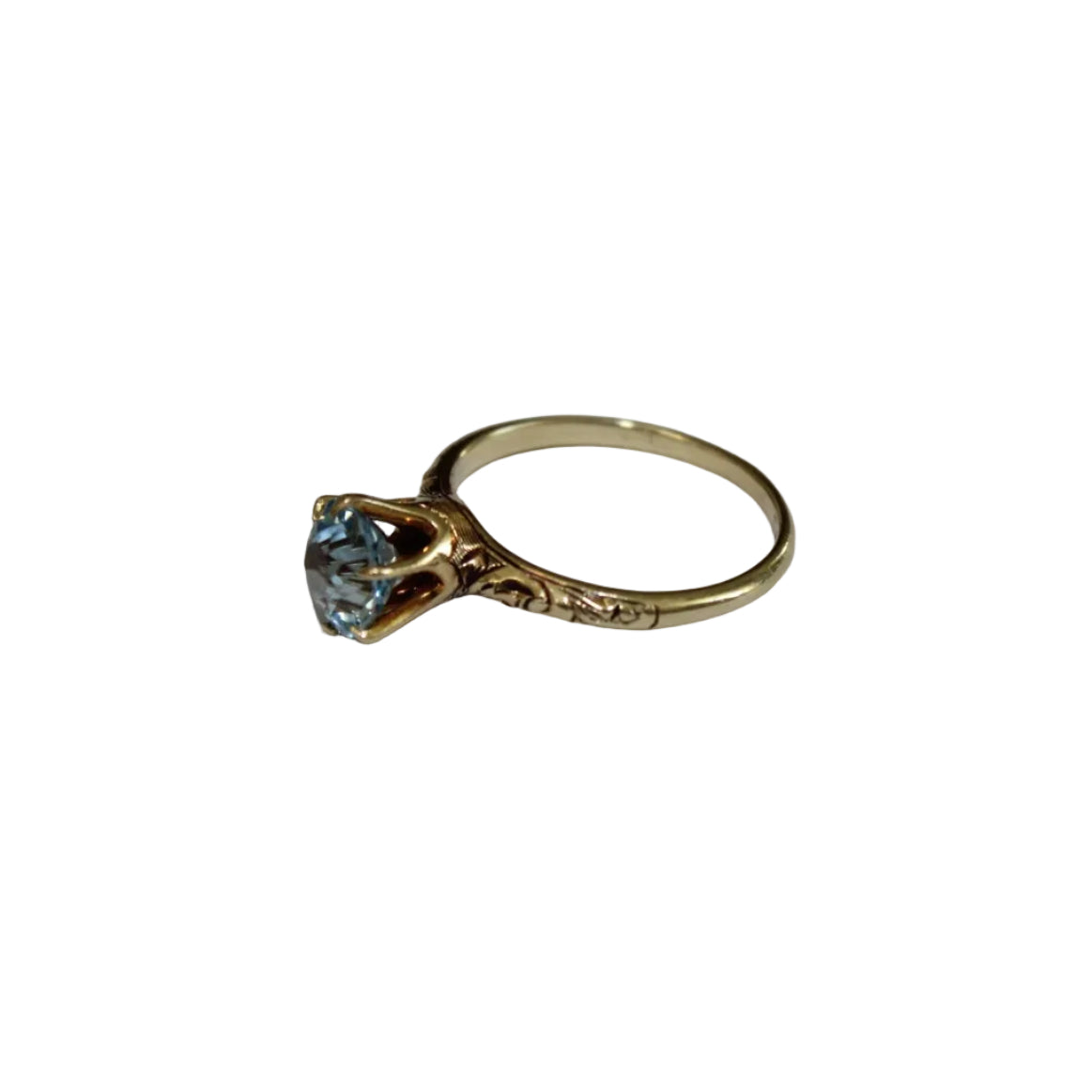 Gold ring with a blue gemstone on a white background