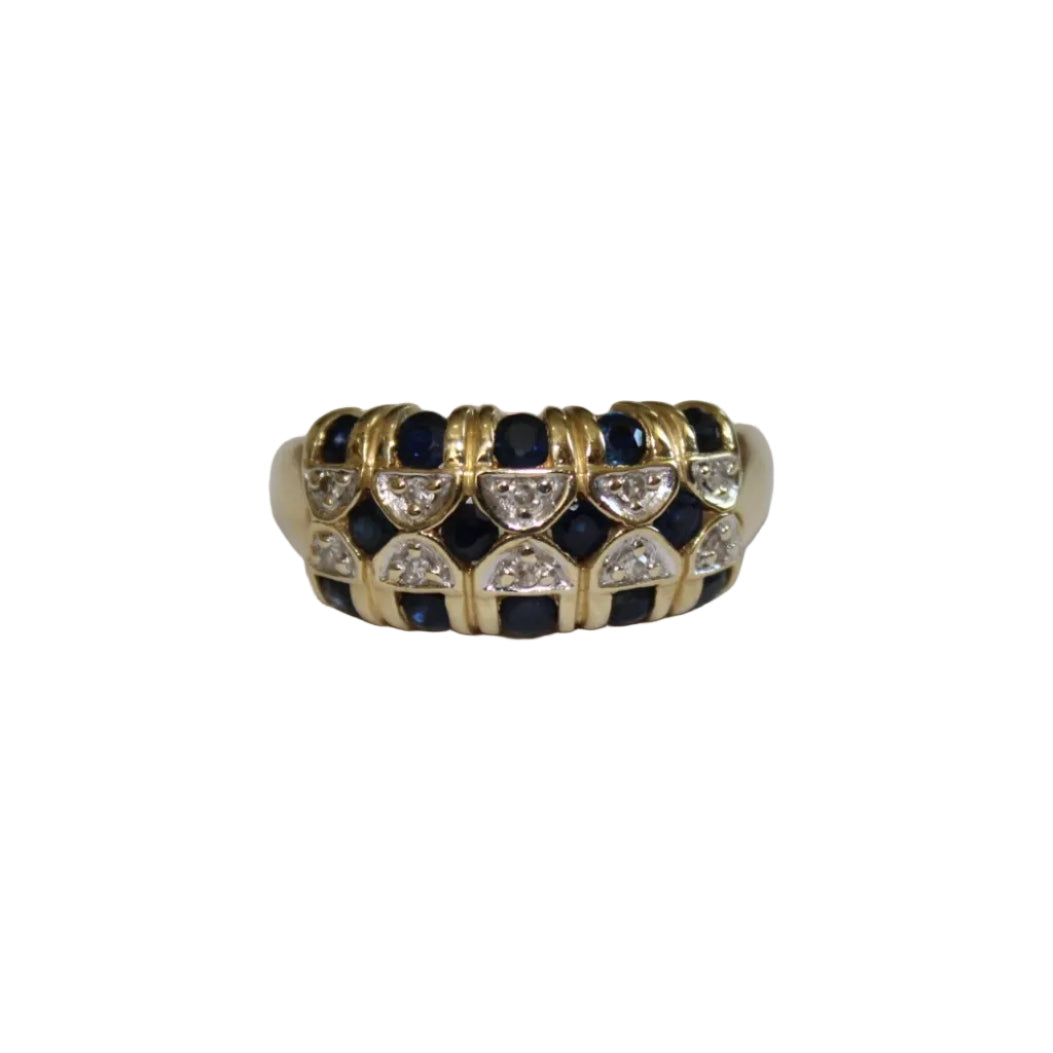 Gold ring with blue gemstones and clear stones on a white background