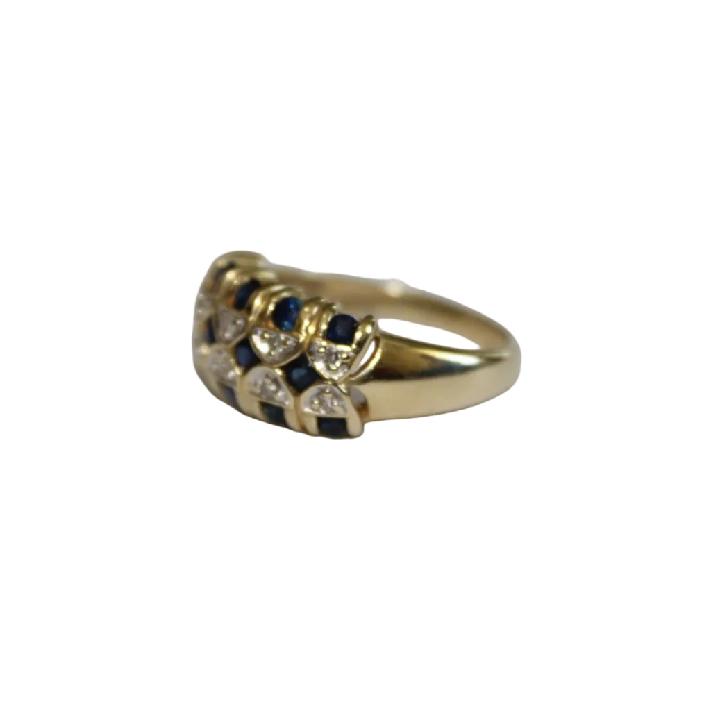 Gold ring with blue and clear gemstones on a white background