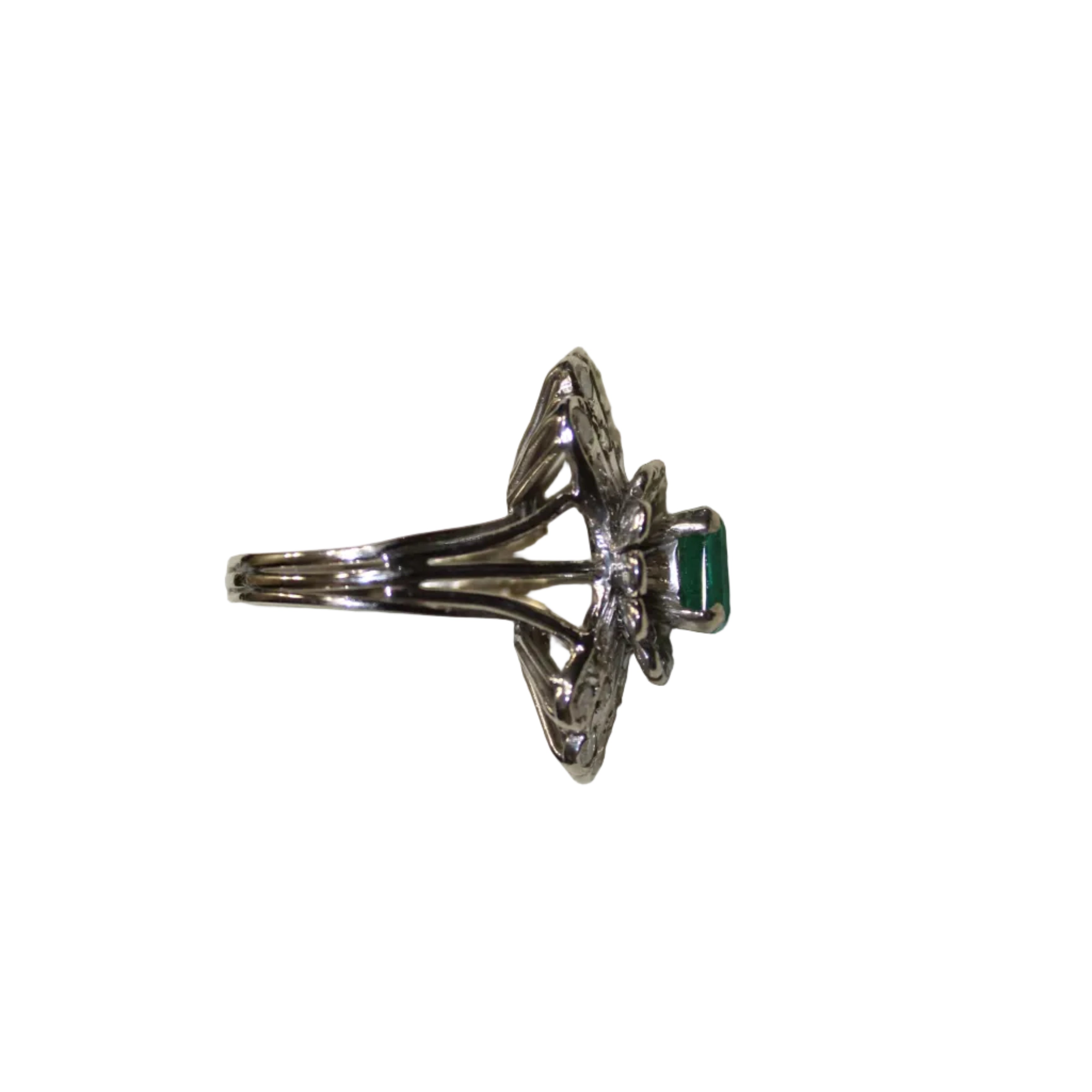 Silver ring with an emerald on a beige background