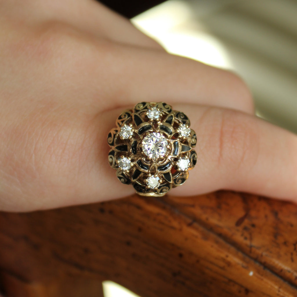 Gold ring with diamonds and black detail on hand. 