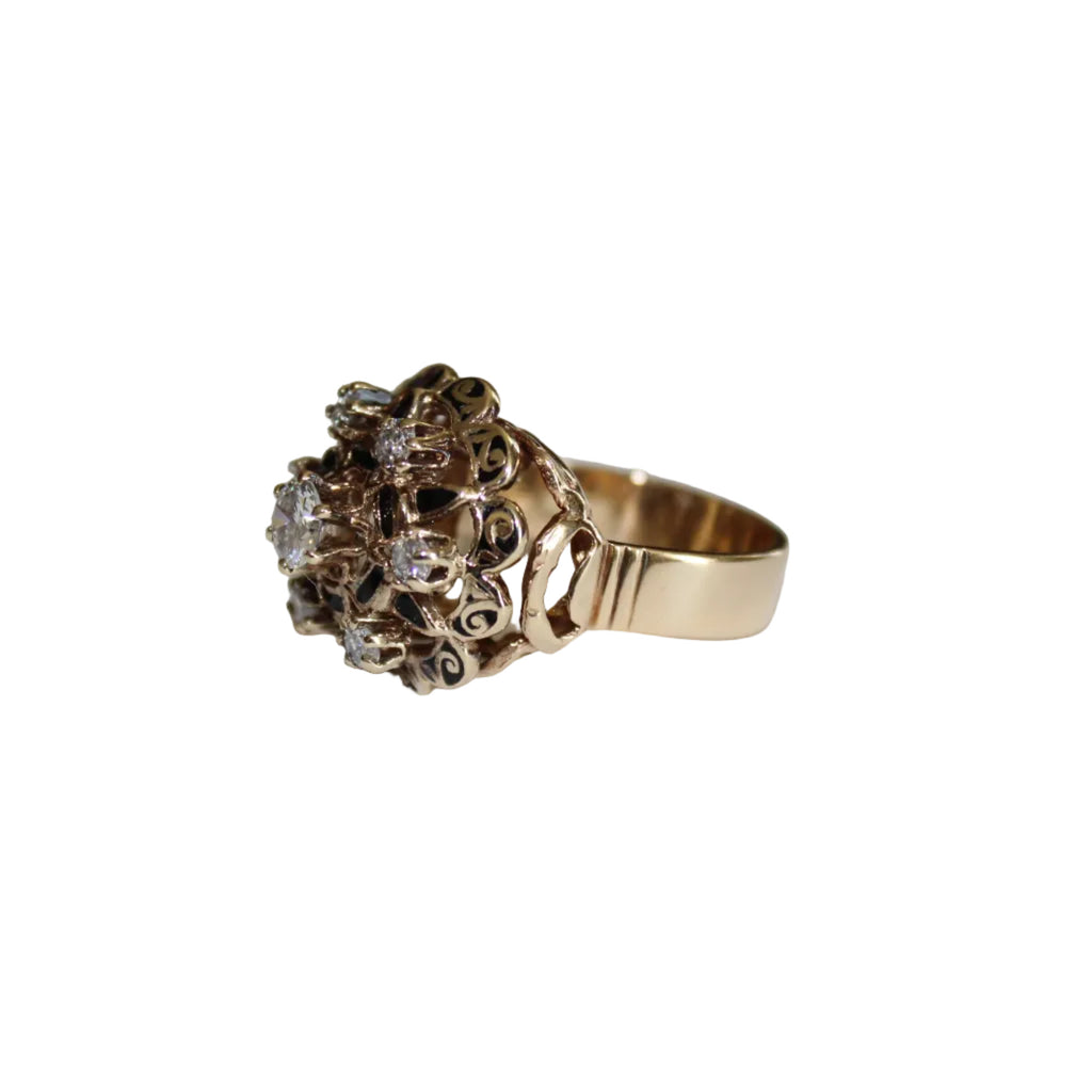 Gold ring with intricate design on a light gray background