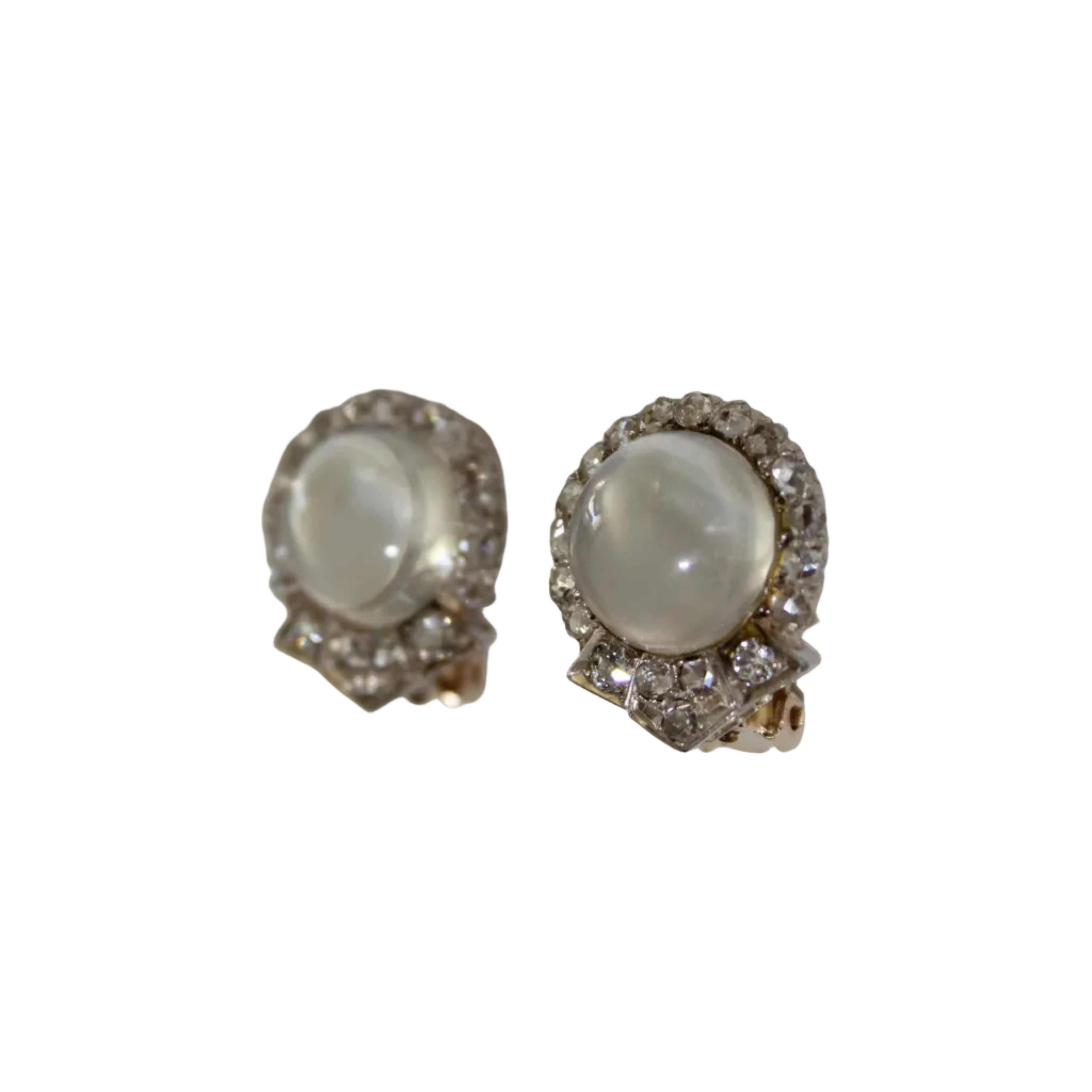 Pair of earrings with a central gemstone and decorative metalwork on a white background