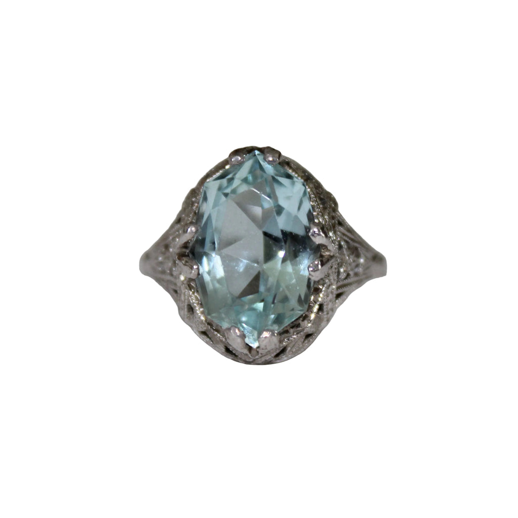 Ring with a large light blue gemstone on a white background